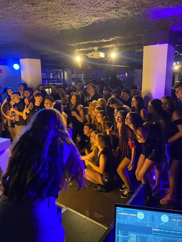 Pista lotada de adolescentes com luz roxa