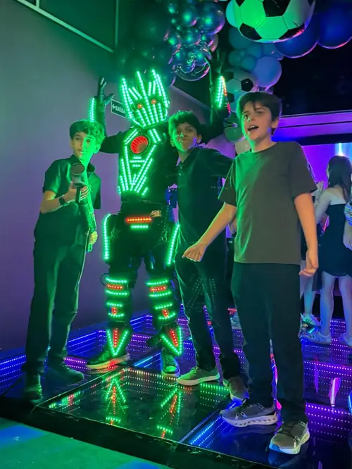 Personagem com traje de LED com convidados na pista